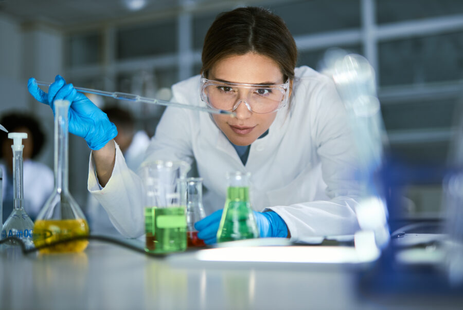 Female chemist working on medical research in laboratory.